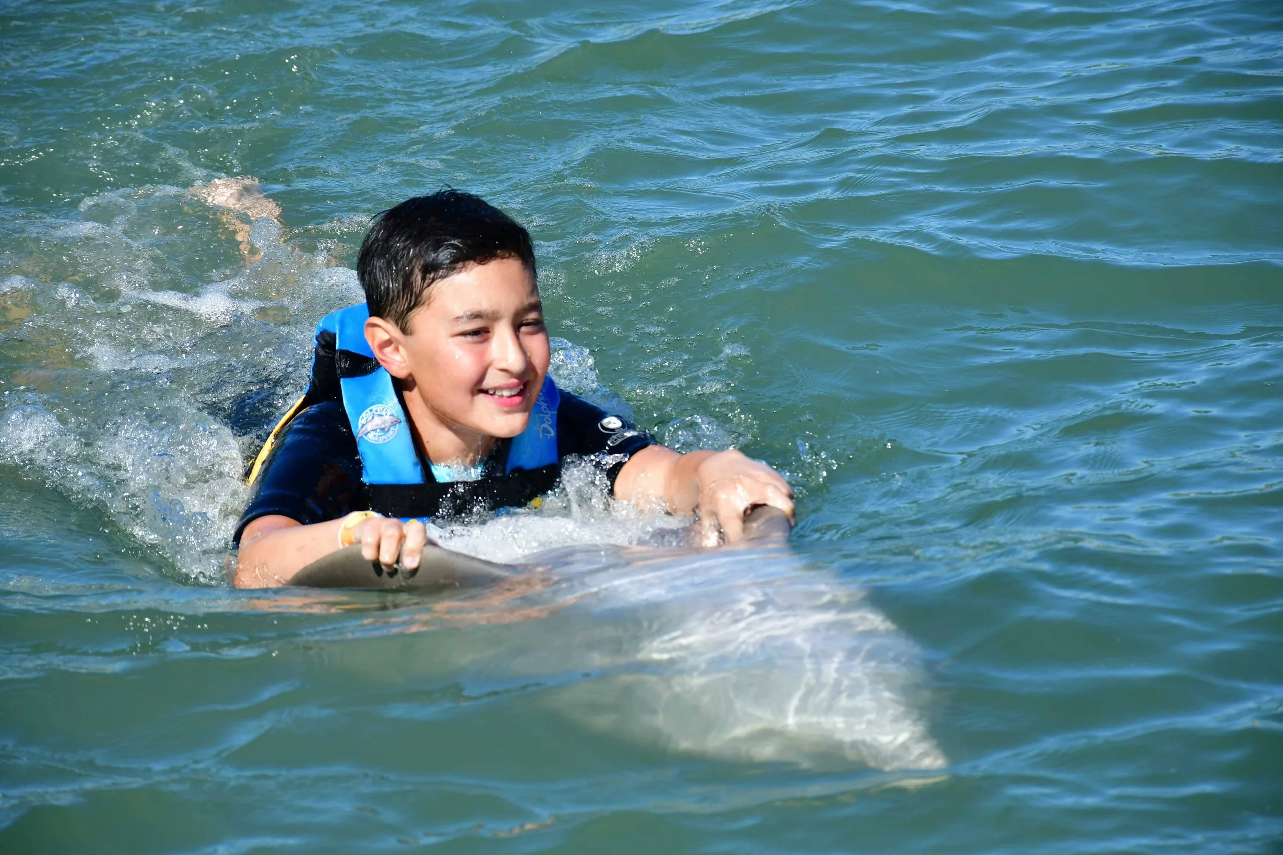 Boy swimming with a dolphin