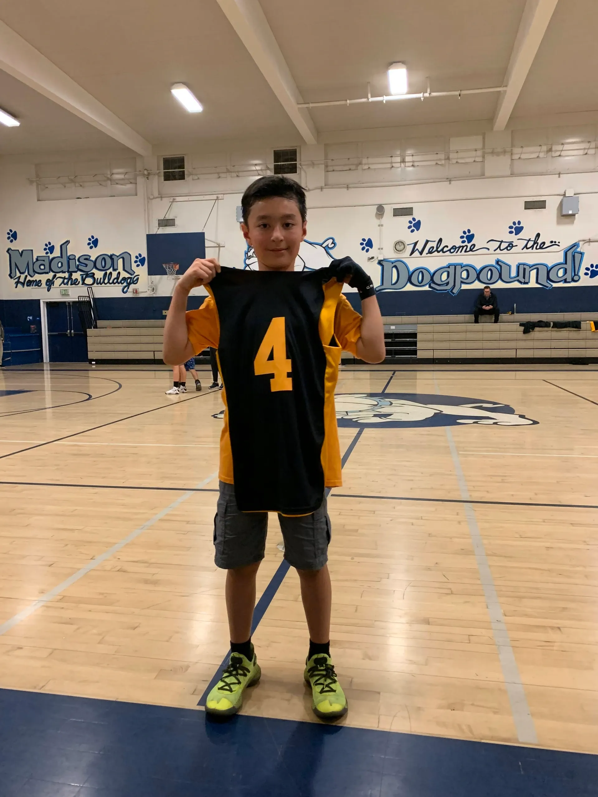 Boy holding his sports jersey at school