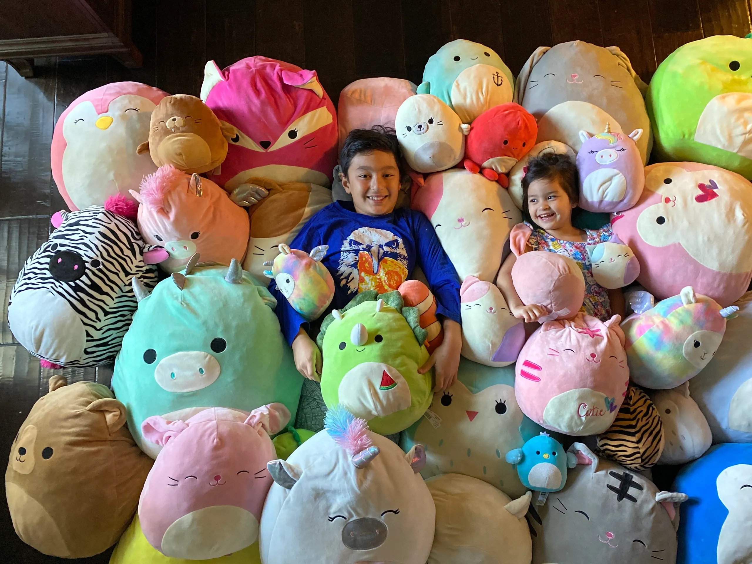 Kids surrounded by colorful plush toys
